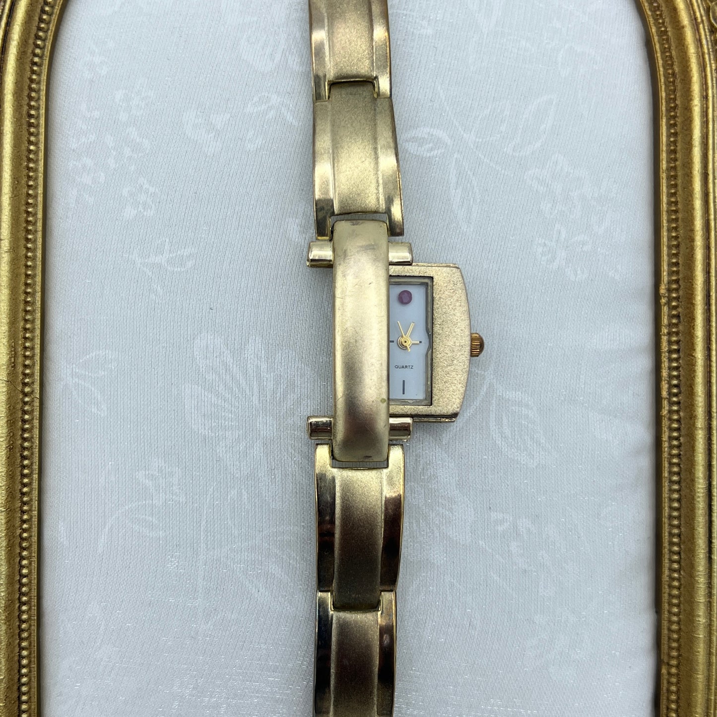 Gold Tone Peek a Boo Watch with Ruby Detailing